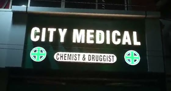 City Medical lit signboard at night, open till 10 PM